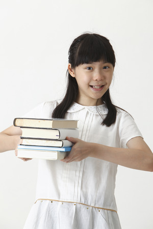 chinese girl holding books looking at cameraの写真素材
