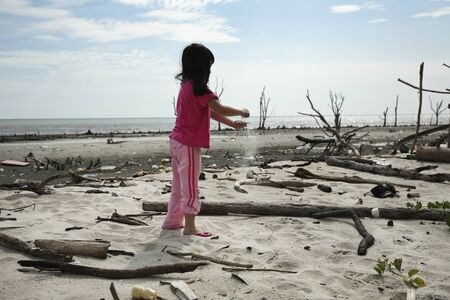 child playing at the polluted beachの写真素材