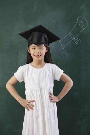 chinese girl with the mortarboard in front of blackboardの写真素材