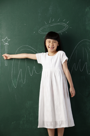 cute litte angel in front of black boardの写真素材