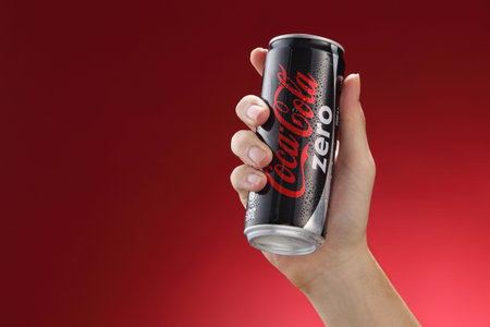 Kuala Lumpur,Malaysia 11th July 2016, Hand hold a  can Coca-Cola Zero on red  background. Coca Cola drinks are produced and manufactured by The Coca-Cola Company.のeditorial素材