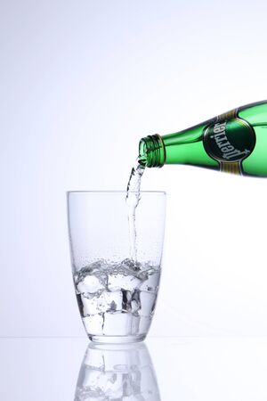 KUALA LUMPUR, MALAYSIA - Feb 17, 2016 pouring perrier mineral water into glass with ice cubeのeditorial素材