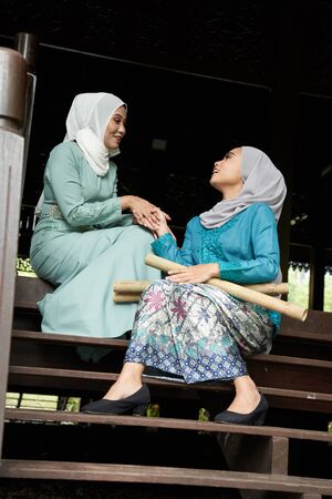 Muslim woman greeting their visitor that they invited for the celebration of Hari Raya. They are all excited to enjoy the festivity for the day.の写真素材