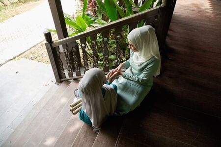Muslim woman greeting their visitor that they invited for the celebration of Hari Raya. They are all excited to enjoy the festivity for the day.の写真素材