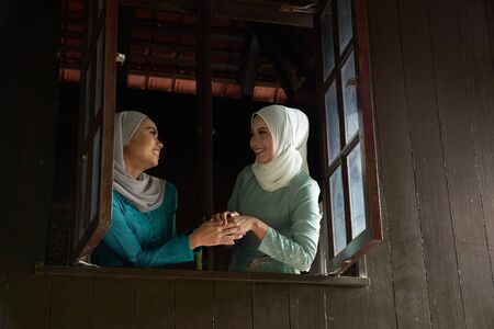 woman greeting each others that invited for the celebration of Hari Raya. They are all excited to enjoy the festivity for the day.の写真素材