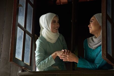 woman greeting each others that invited for the celebration of Hari Raya. They are all excited to enjoy the festivity for the day.の写真素材