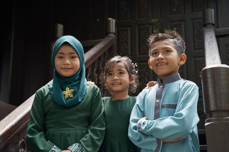Malay family in Malay traditional showing their happy reaction during Hari Raya celebration.