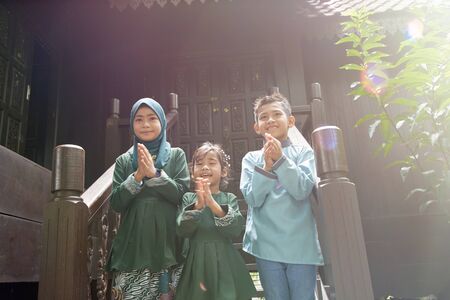 Malay family in Malay traditional showing their happy reaction during Hari Raya celebration.の写真素材