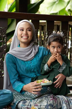 mother with traditional clothing carry her daughterの写真素材