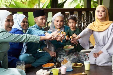 group of malay family breaking the fast together they showing the cheese ringの写真素材