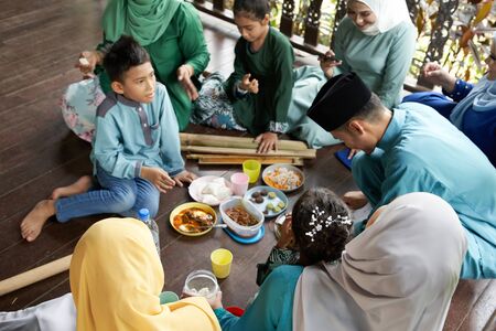 focus on the foreground group of malay family breaking the fast togetherの写真素材