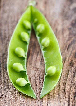 Green young green peas on a wooden background.selective focusの写真素材