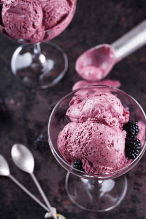 BlackBerry ice cream with fresh blackberries in a glass sundae dish. selective focusの写真素材