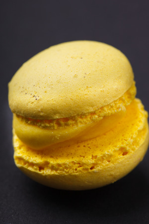 Yellow mini macaroons isolated on a black background.selective focusの写真素材