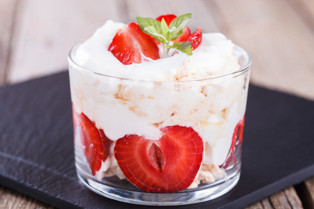 Eton Mess - Strawberries with whipped cream and meringue in a glass beaker. Classic British summer dessert.selective focusの写真素材