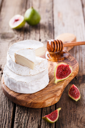 Brie cheese on a wooden Board with fresh figs and honey.selective focus.の写真素材