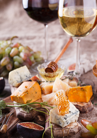 Grape, cheese, figs and honey with a glasses of red and white wine.Cheese Board.selective focusの写真素材