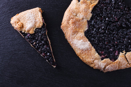 Galette with blueberries  on a black background.の写真素材