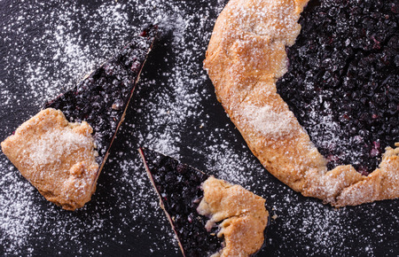 Galette with blueberries  on a black background.の写真素材