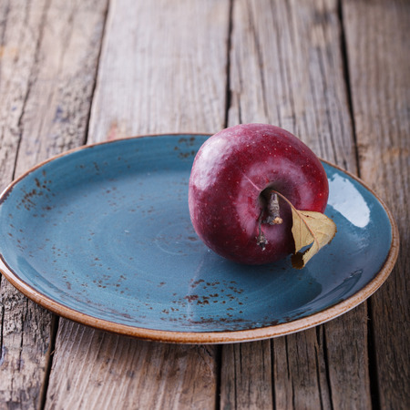 Red Apple on a blue plate.selective focus.の写真素材