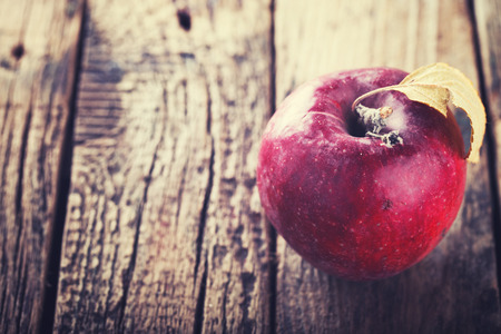 Red Apple on wooden background.Autumn still life.Toned image. Vintage style.selective focus.の写真素材