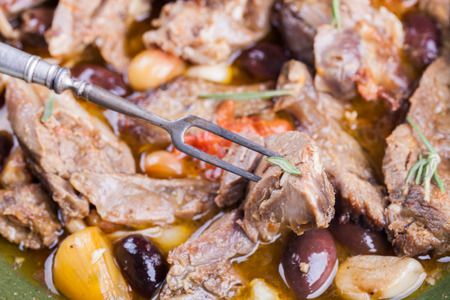 Lamb meat cooked in a tagine with olives, garlic, lemon and rosemary.の写真素材