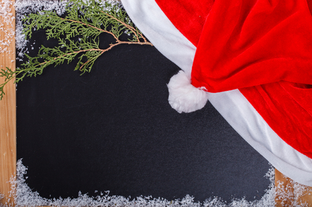 Christmas and New Year background. wooden Board with a red cap of Santa Claus.Copy space.selective focus.の写真素材