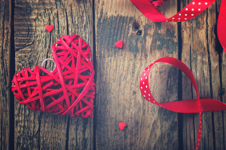 Heart decorated with a red ribbon for a romantic Valentine's day celebration, on vintage wooden background.Toned image.Vintage style.selective focus.の写真素材