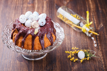 Easter cake with chocolate decorated with colored quail eggs and Mimosa.selective focus.