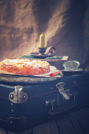 Apple cake on a vintage suitcase in powdered sugar.Toned image.Vintage style.selective focus.の写真素材