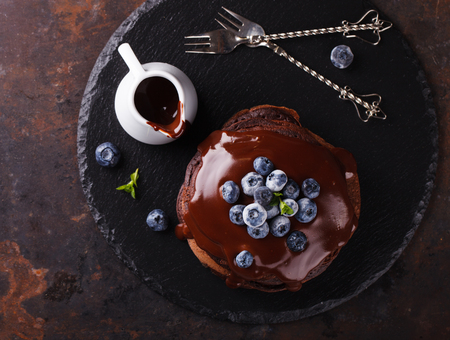 Chocolate pancake with chocolate frosting,blueberries and mint.selective focusの写真素材