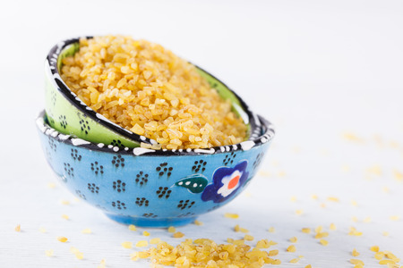 Raw bulgur wheat in traditional Turkish hand made ceramics ware.selective focus.の写真素材