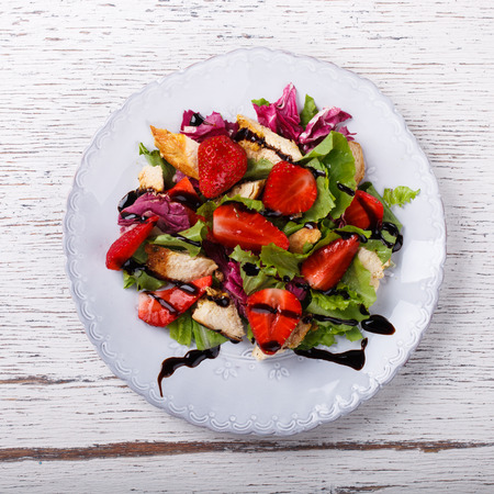 Salad with fresh strawberries,herbs and chicken meat,tossed with balsamic vinaigrette. Healthy food or diet concept.selective focus.の写真素材