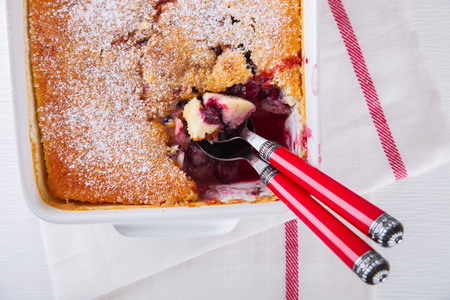 Clafoutis with cherries in a ceramic form on a white background. top view. selective focus.の写真素材