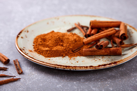 Cinnamon sticks and cinnamon powder on the plate.sの写真素材