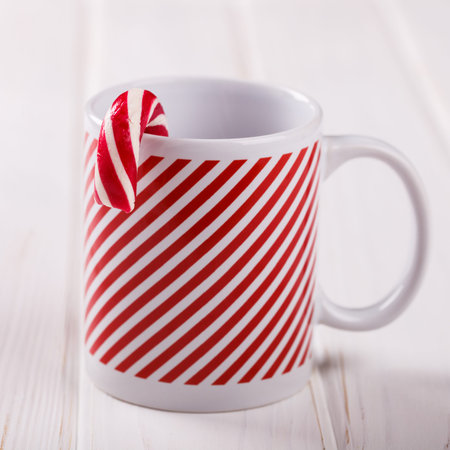 Striped Christmas Cup with candy, for Celebratory Drinks, on a White Background. selective focus.の写真素材