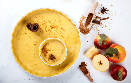 Baking Background. Ingredients  for baking Apple Pie  - apples, spices, flour,  rolling pin, eggs, egg yolks, butter served, milk on white background. selective focus.の写真素材