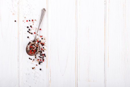 Black, White and Red Pepper, and Salt in Spoon on white Background.の写真素材