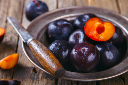 Plum in plate on a blue background. selective focus.の写真素材