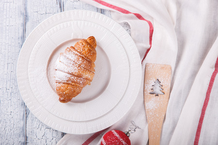 Christmas or New Year pastries,Croissant.Winter Holidays Concept.Holiday Decorations. White Wooden Background with crackling effect.top view. Copy space. selective focus.の写真素材