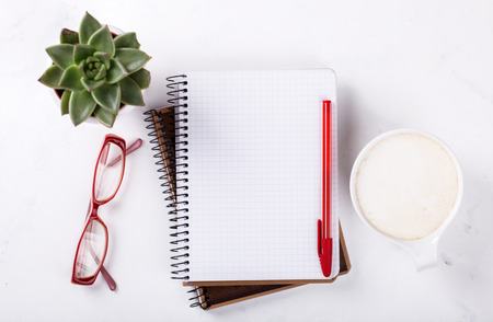 Notepad with pen, glasses , coffee and flower on the table.Business Concept .Copy space. selective focus.の写真素材