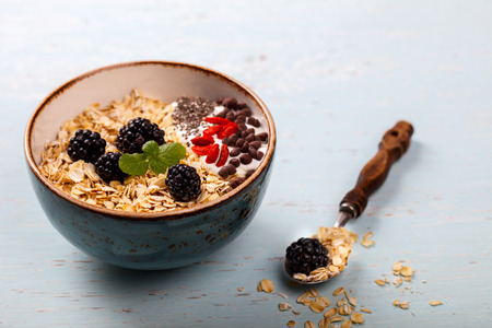 Oatmeal,Granola with Yoghurt, with Fresh berries,Blackberries,Goji berries,Chia seeds,chocolate.Healthy dry Breakfast.Diet Concept.Copy space for Text.selective focus.の写真素材