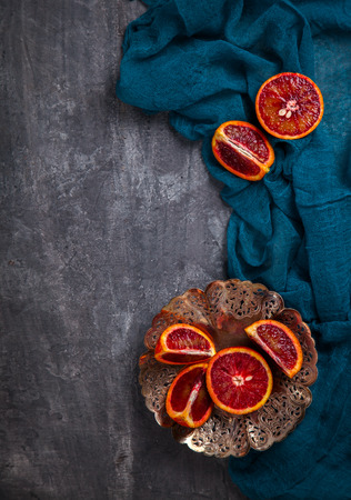 Blood Orange in a metal Plate with a knife on a dark Background.Vintage style.Food or Healthy diet concept.Vegetarian.Copy space for Text. selective focus.の写真素材