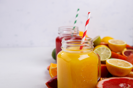 Juices Fresh Orange and Citrus on a White Background.Healthy Beverage.Food or Healthy diet concept.Mixed Colorful Tropical Background.Copy space for Text. selective focusの写真素材