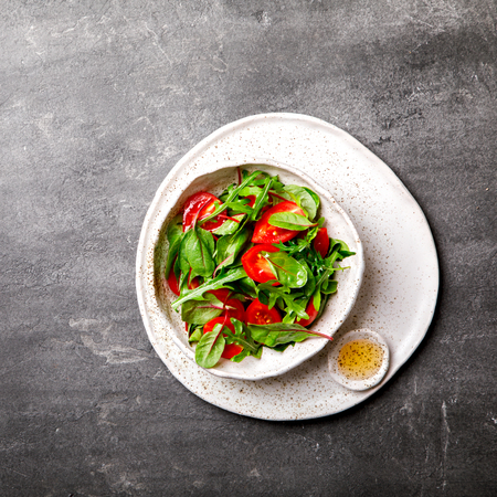 Salad with baby Spinach, arugula and Fresh Cherry Tomatoes Flax seeds and Olive oil.Food or Healthy diet concept.Super Food.Vegetarian.Top View.Copy space for Text. selective focus.の写真素材