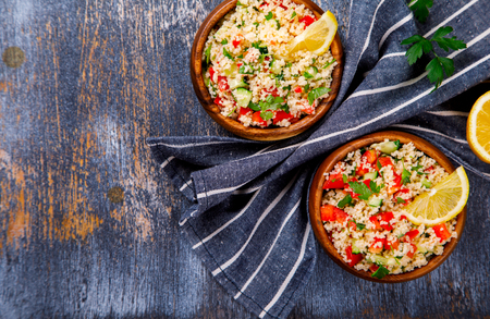 Tabbouleh salad with couscous on the plate.Traditional middle eastern or arab dish.Vegetarian.Parsley,pepper,cucumber,tomato,lemon.Middle eastern meze.Food or Healthy diet concept.Copy space for Text.の写真素材