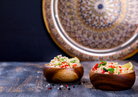 Tabbouleh salad with couscous on the plate.Traditional middle eastern or arab dish.Vegetarian.Parsley,pepper,cucumber,tomato,lemon.Middle eastern meze.Food or Healthy diet concept.Copy space for Text.の写真素材