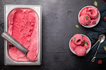 Ice cream Raspberry  in white bowl on the black background.Dessert.Copy space for Text.Sorbet Shariq form.selective focus.の写真素材