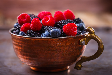 Berry Fresh in a copper cup on the Metal Background. Blackberries,Bramble,raspberry with mint.Food or Healthy diet concept.Super Food.Vegetarian.Copy space for Text.selective focus.の写真素材