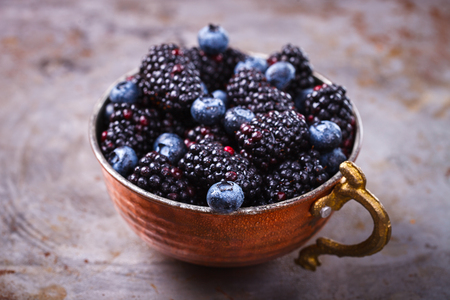 Berry Fresh in a copper cup on the Metal Background. Blackberries,Blueberry.Food or Healthy diet concept.Super Food.Vegetarian.Copy space for Text.selective focus.の写真素材